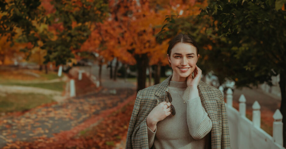 Junge Frau hat Anleihen gekauft und lächelt glücklich in die Kamera.