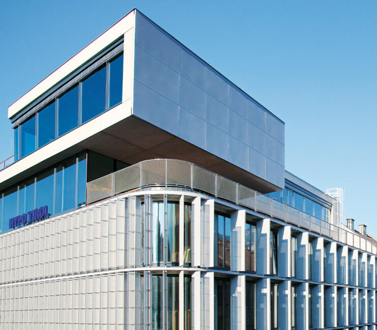 Architektonisch markantes Gebäude der Hypo Tirol Bank mit moderner Glasfassade und klaren Linien unter blauem Himmel