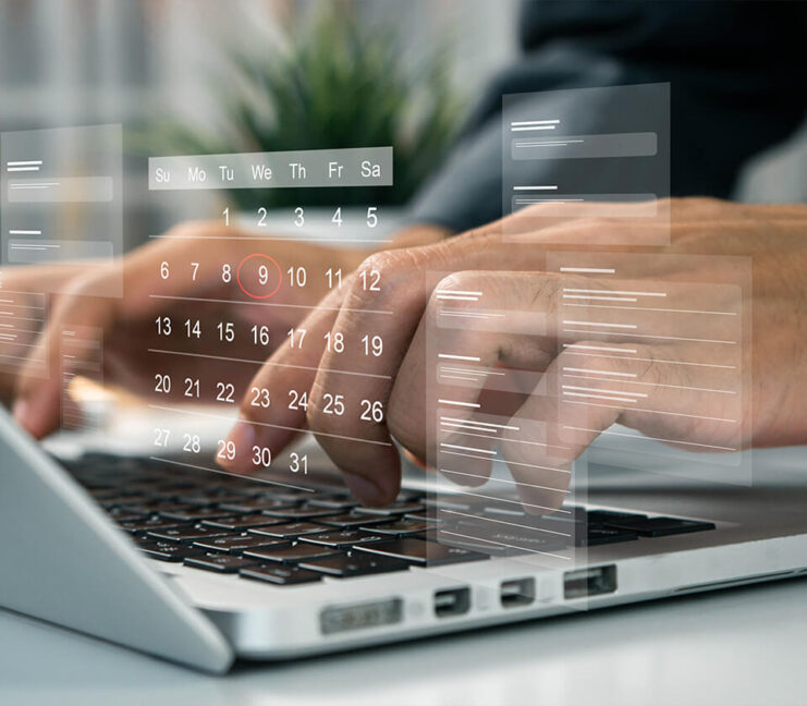Person tippt auf Laptop-Tastatur, darüber schwebt ein digitaler Kalender mit markiertem Datum.