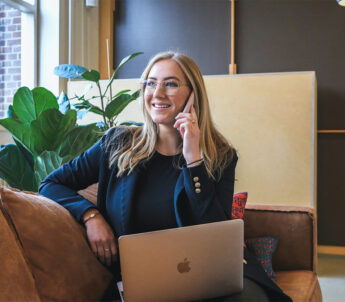 Eine junge Frau, die am Telefon ein Bewerbungsgespräch für ein Traineeprogramm bei der Hypo Tirol vereinbart.