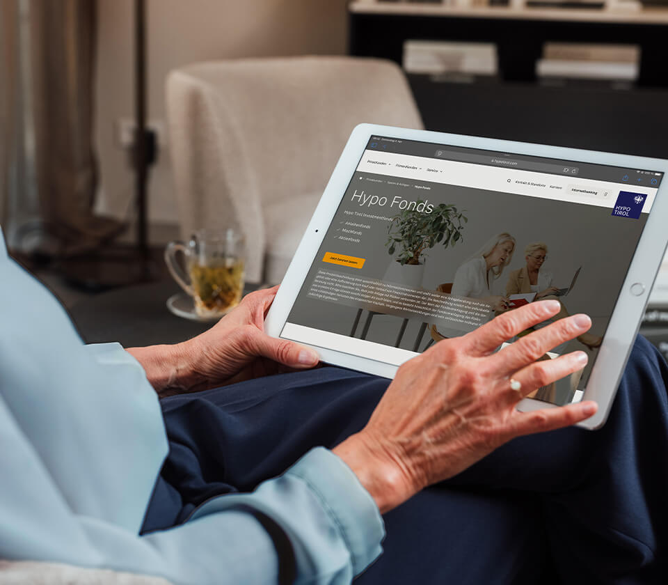 Person hält ein Tablet mit geöffneter Webseite der Hypo Tirol Bank zum Thema Fonds.