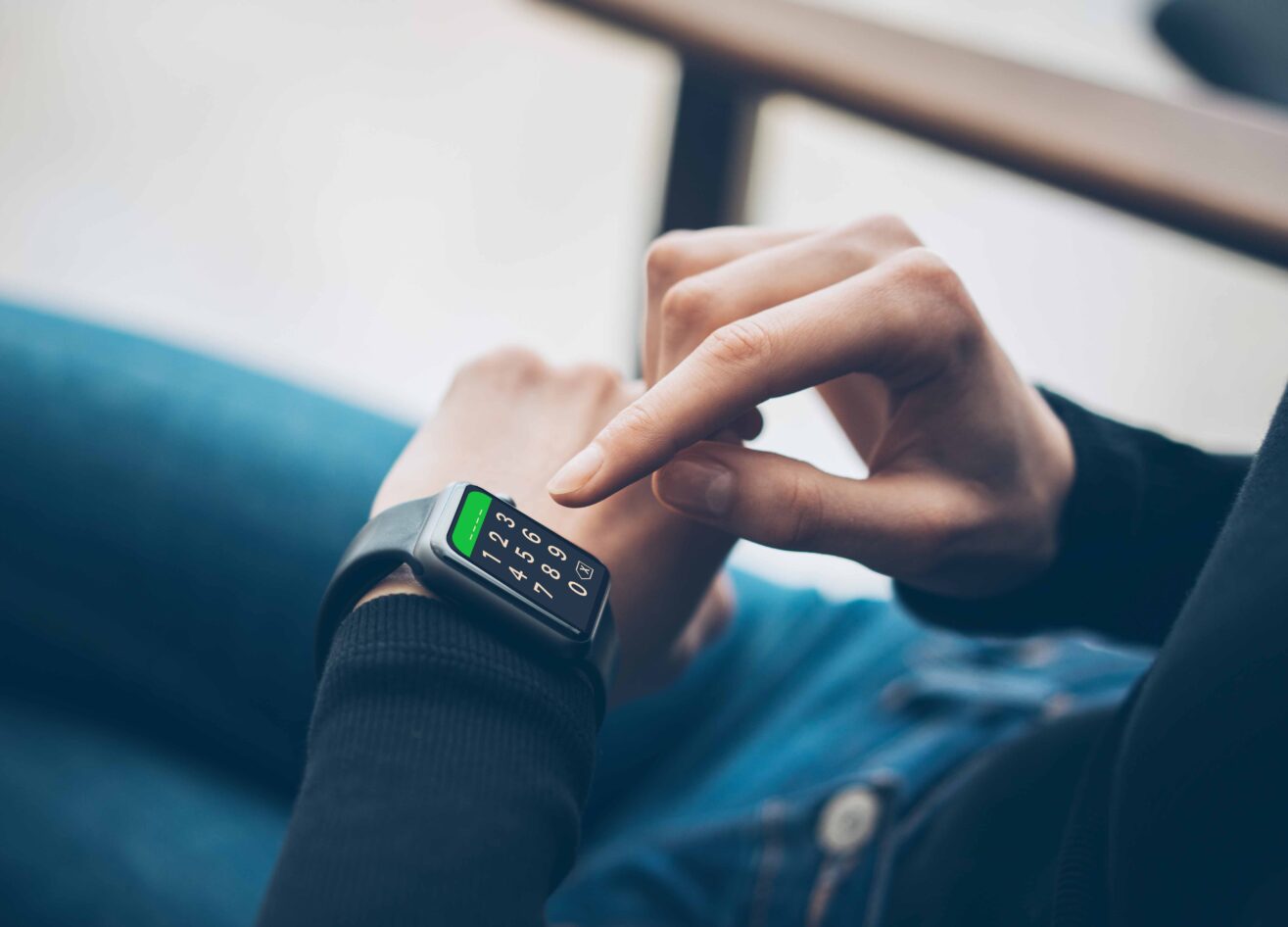 Smartwatch mit digitaler PIN-Anzeige, die von einem Mensch bedient wird.