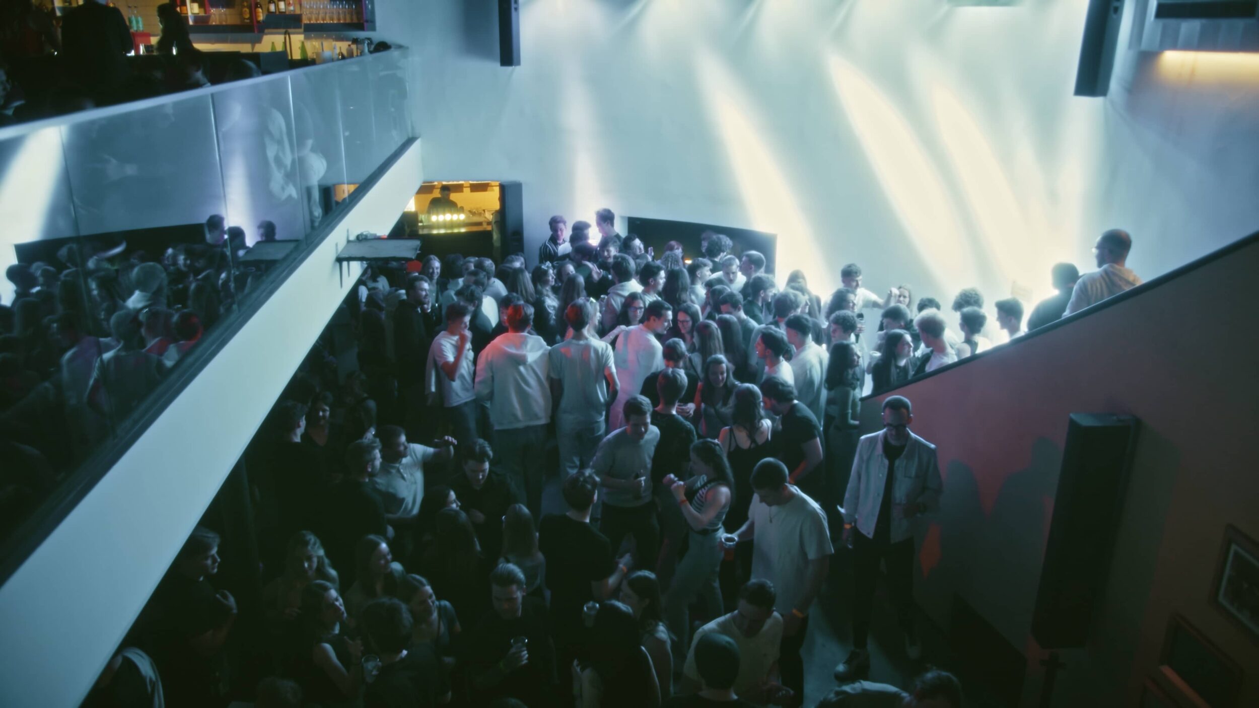 Viele junge Erwachsene auf einer Tanzfläche in einer Discothek bei ausgelassener Stimmung.