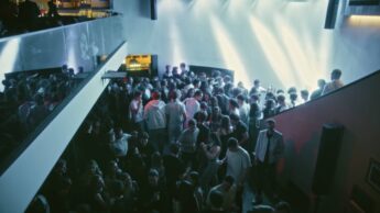 Viele junge Erwachsene auf einer Tanzfläche in einer Discothek bei ausgelassener Stimmung.