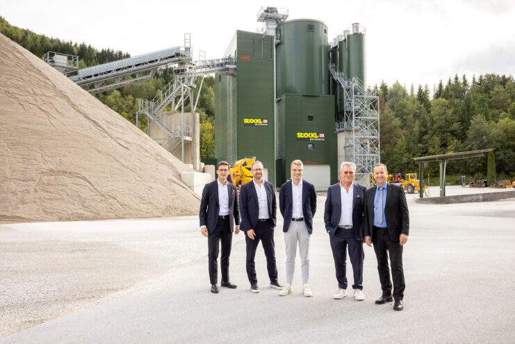 5 Männer stehen vor einem Betonwerk.