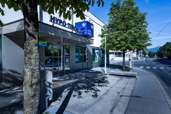 Außenansicht des Hypo Tirol Standorts Technik mit Bäumen.