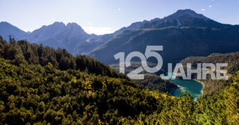 Tiroler Berglandschaft. 125-Jahr-Schriftzug der Hypo Tirol in weiß
