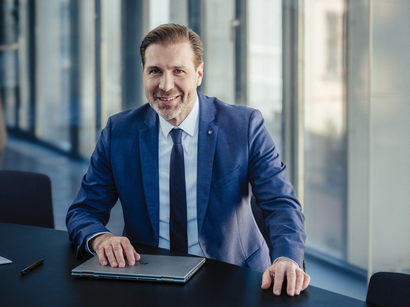 Berater Robert Lang lachend in einem modernen Büro.